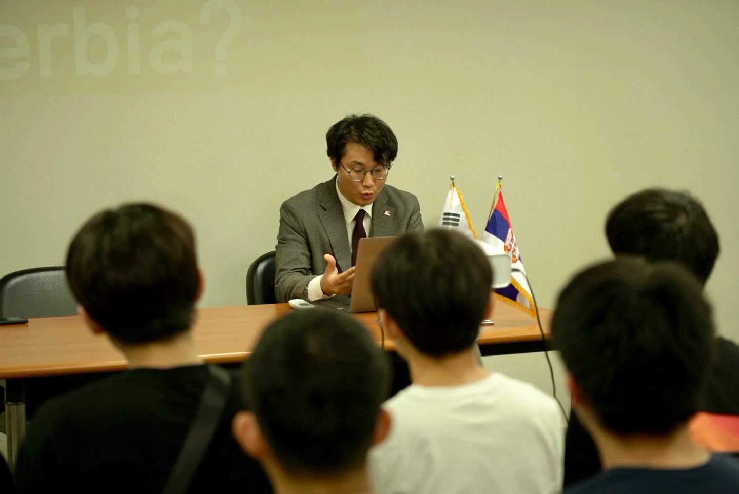 박새솔이 한국에서 세르비아를 소개하는 강연을 하는 모습, 책상 위에 한국과 세르비아 국기